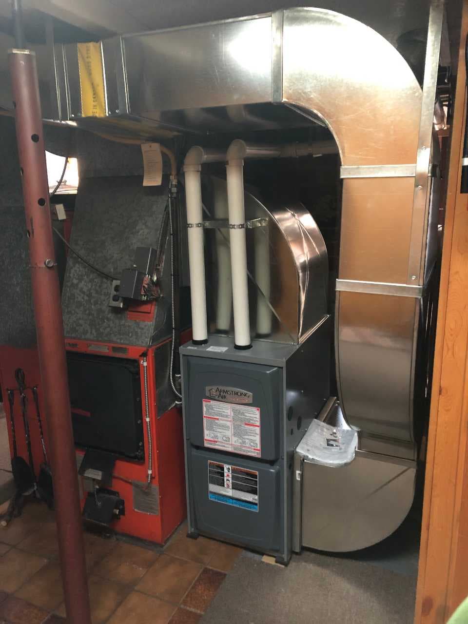 Wood burner installed alongside forced-air furnace equipment